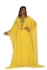 Woman wearing a yellow embroidered dress against a plain background