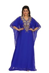 Woman wearing a blue dress with gold embroidery on a white background